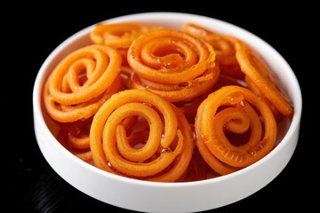 Fototapeta premium Sweet indian jalebi spiral pastries in a white bowl