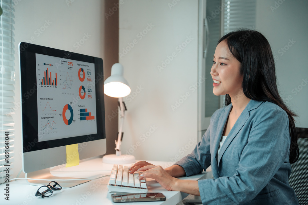 Poster young professional examining charts and graphs on a desktop computer, working with business data and