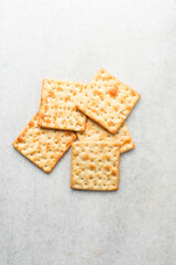 Overhead view of homemade crackers on white marble countertop, top view of cracker biscuits on white background