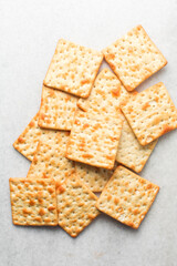 Overhead view of homemade crackers on white marble countertop, top view of cracker biscuits on white background