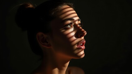 Female model partially lit by slatted shadows, face tilted upwards, strong interplay of light and darkness symbolizing duality.
