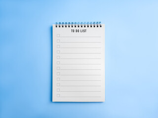 To do list and checklist template on spiral notebook with blue background, symbolizing...