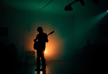 Silhouetted figure playing guitar in dimly lit room, passion, music