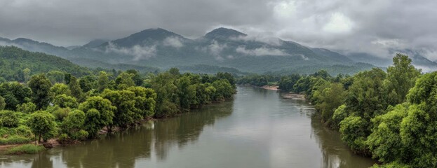 Panoramic view of a river winding through lush green valley and misty mountains