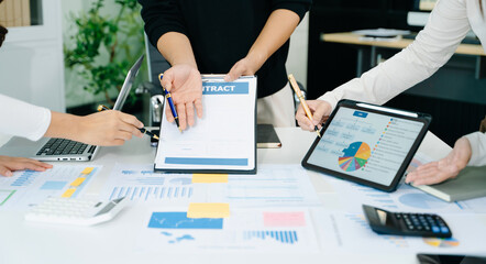 Businessman hand using laptop and tablet with social network diagram and two colleagues discussing...