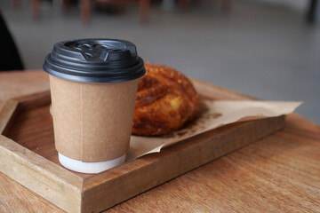Freshly brewed coffee and pastry on wooden tray
