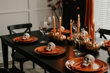 Halloween table setting with skulls candles and pumpkins