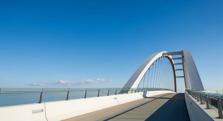 Obraz premium Modern architectural arch bridge with a pedestrian walkway over the sea.