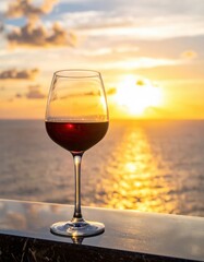 Red wine in glass at sunset overlooking ocean