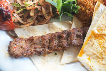Grilled kebab served with fresh sides at a restaurant