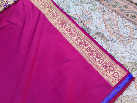 Elegant magenta Banarasi silk saree with contrasting purple pallu and rich golden embroidery on the borders, ideal for traditional Indian weddings, cultural celebrations, and ethnic festive fashion