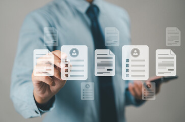 Businessman conducting online surveys and digital form checklists on a virtual screen, document management system, online document database and file management process.