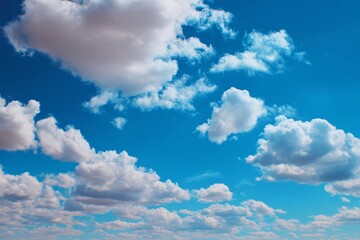 Beautiful white fluffy clouds drift across the vast blue summer sky