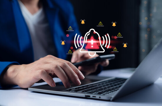 System warning alert cybersecurity risk on laptop and smartphone, businessman receiving critical notification, data protection warning and online security threat in digital network. - Powered by Adobe