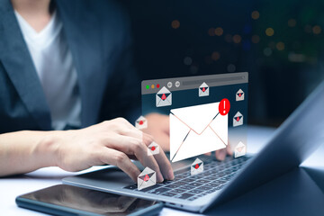 Laptop with floating email alert icons, symbolizing phishing attacks, spam threats, and cybersecurity risks as a businessman types on computer in modern office environment.