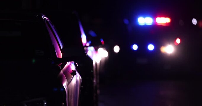 Abstracted view of police car pulling over a vehicle on a city street at night.