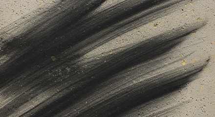 Close-up view of dark, textured brushstrokes on a light, speckled surface, creating an abstract composition.