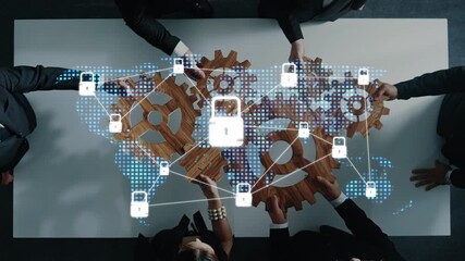 A high-angle view of a business meeting showcasing professionals collaborating over a table with gears and digital security symbols, emphasizing teamwork in technology. Raster - Powered by Adobe