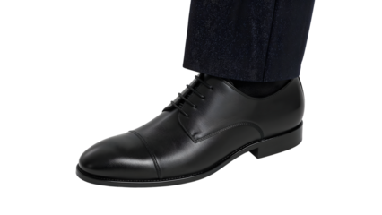 Classic black leather oxford dress shoe with cap toe and laces paired with formal dark trousers isolated on the transparent background