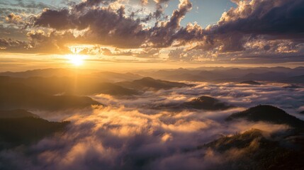 Obraz premium Golden sunrise over misty mountain peaks with dramatic clouds