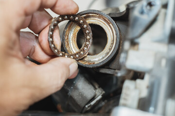 Mechanic check and replace Motorcycle wheel bearings , working in garage . repair and  maintenance motorcycle concept .selective focus