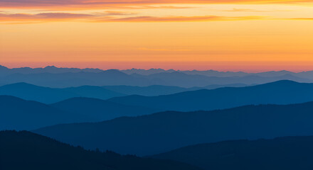 Majestic mountain range silhouette with vibrant sunset sky and layered peaks