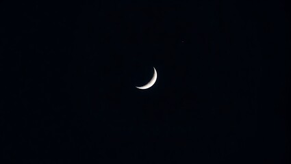 Crescent moon and a star in a dark night sky view