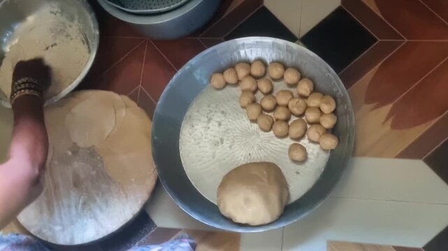 Preparing Indian flatbreads/sweets like Puri, Chapati, or Modak involves a kitchen process: kneading the dough, shaping small balls, and rolling with a belan before cooking.