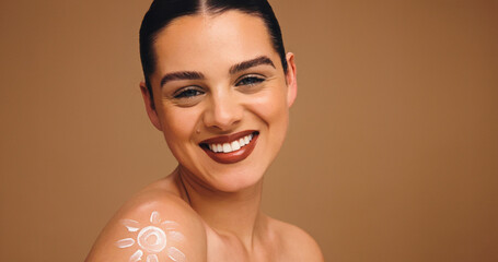 Portrait, sunscreen and woman in studio, smile and dermatology on brown background. Mockup space,...