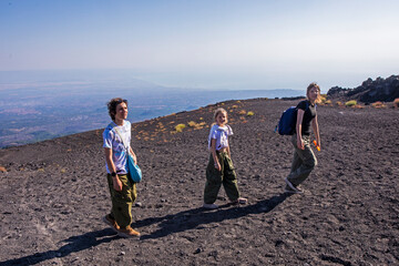 happy teenager hikes to the craters of the volcano Etna early in the morning. Active school holidays