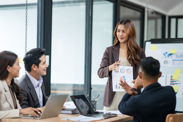 Group of Asian businesspeople sits down for a business investment planning meeting.	
