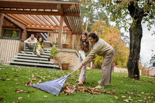 Raking autumn leaves in garden. - Powered by Adobe