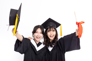 Excited Teenage girls wearing graduation gown and showing  diploma