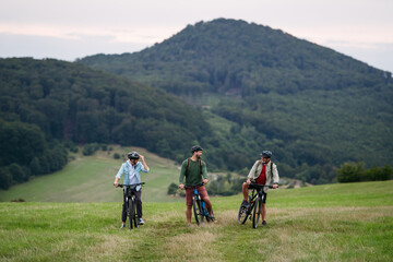Grandfather, father and teen boy on cycling trip.
