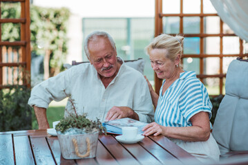 Senior couple looking at family photo album together.