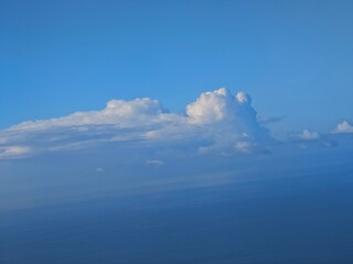 Cloud formations over the ocean during a clear day provide a serene view from above