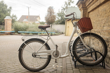 Fototapeta premium Retro bicycle parked in front of an old house with brick wall in the village.
