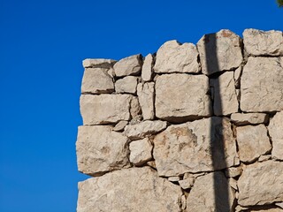 Ancient stone wall under clear blue sky in a historic location during midday