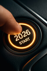 Finger presses a start button illuminated with the year 2026, symbolizing new beginnings and the future.
