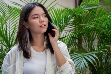 Young Japanese businesswoman talking on the phone with a worried expression