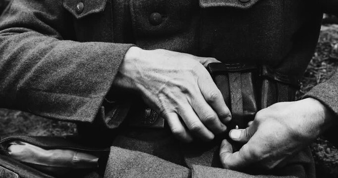 Historical Re-enactment Black And White Video. World War II German Soldier Cleaning Rifle. Soldier Preparing Weapon. German Military Ammunition Of A German WW2 Soldier