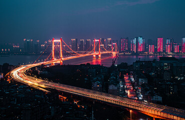 a very nice view of the bridge at night with city lights