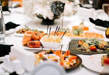 Elegant banquet table setting with an array of gourmet dishes and fresh fruits