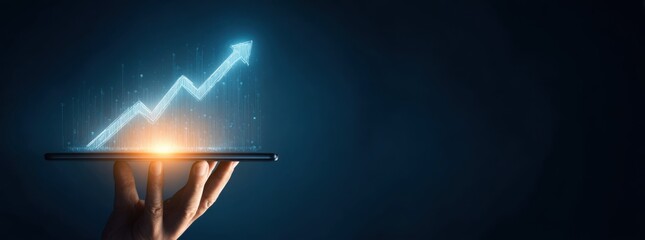 Hand holding tablet displaying upward trend graphic