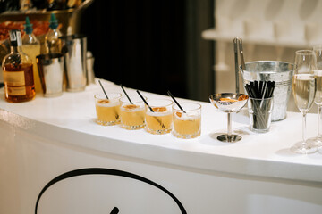 Cocktails lined up at a chic bar ready for guests during an evening gathering