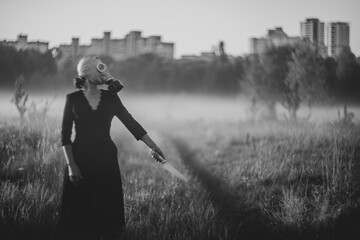  A mysterious masked woman holding knife in foggy field
