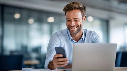 Fototapeta premium Man is sitting at a desk with a laptop and a cell phone