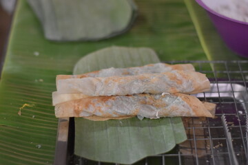 Corns Being Roasted On A Grilling Grid, Glutinous rice with sugar and coconut, wrapped in banana...