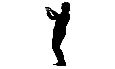 Silhouette of a businessman using a tablet.
