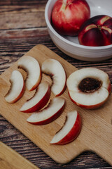 Durazno rojo y manzana roja en rebanadas con fondo rústico de madera